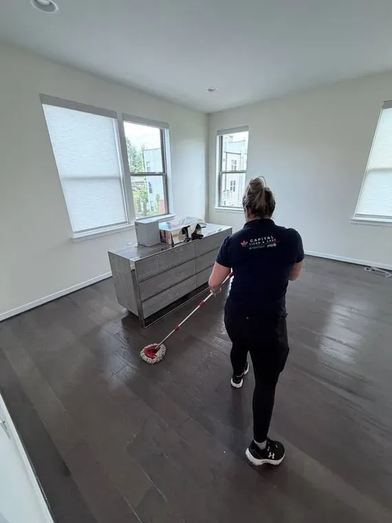 Capital Clean Care employee mopping a hardwood floor