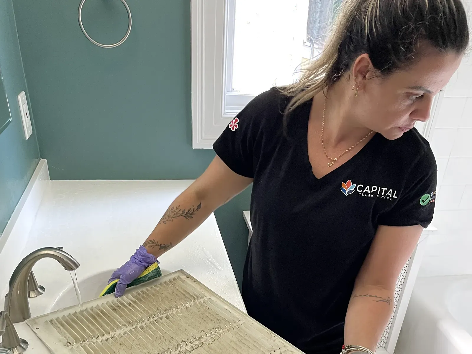 Capital Clean Care professional washing a heavily soiled HVAC vent filter during a detailed deep cleaning service