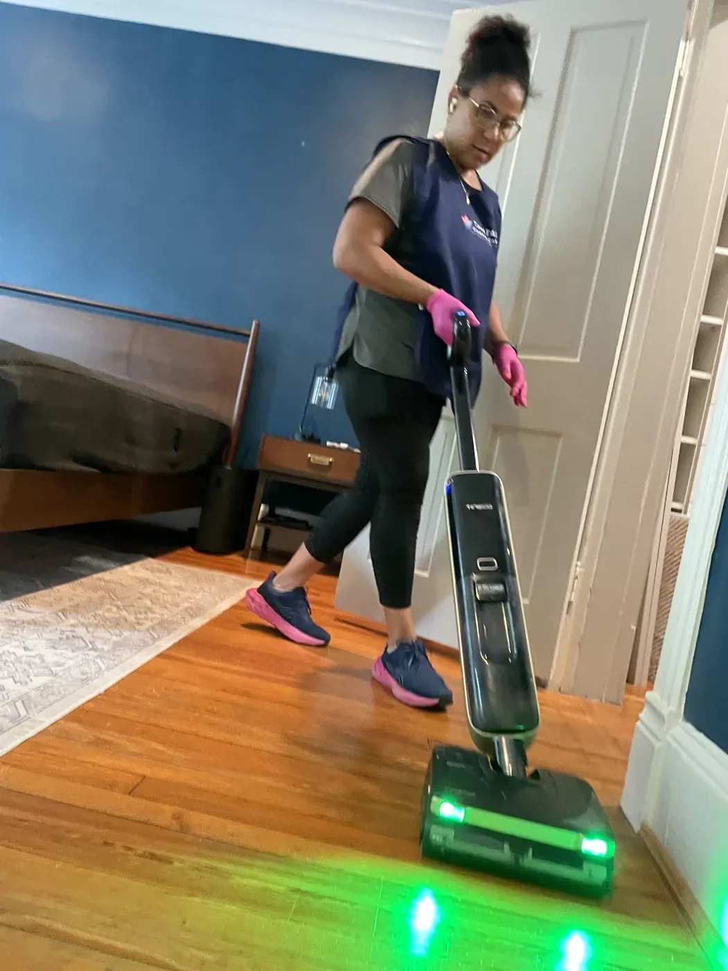 Capital Clean Care professional using powered floor-care equipment on hardwood flooring