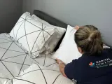 Capital Clean Care employee making a bed in a condo bedroom