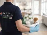 Capital Clean Care employee carrying a basket of plant-based cleaning products