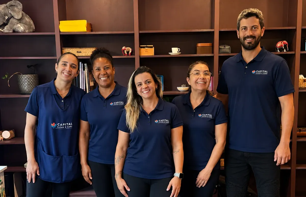The Capital Clean Care team in navy uniforms, standing together in a client's home
