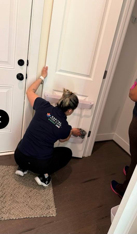 Capital Clean Care technician assessing and cleaning door frame detail